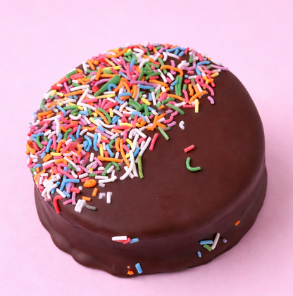 Chocolate wagon with colorful sprinkles on a pink background